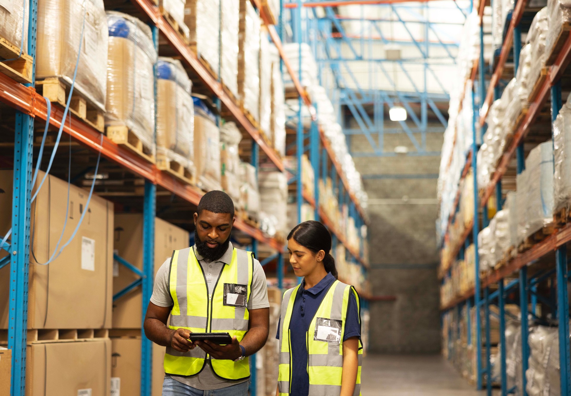 Logistics, teamwork and people in warehouse with tablet for planning, inspection and inventory. Distribution, man and woman storage with online digital app for checking stock, sales or shipping order